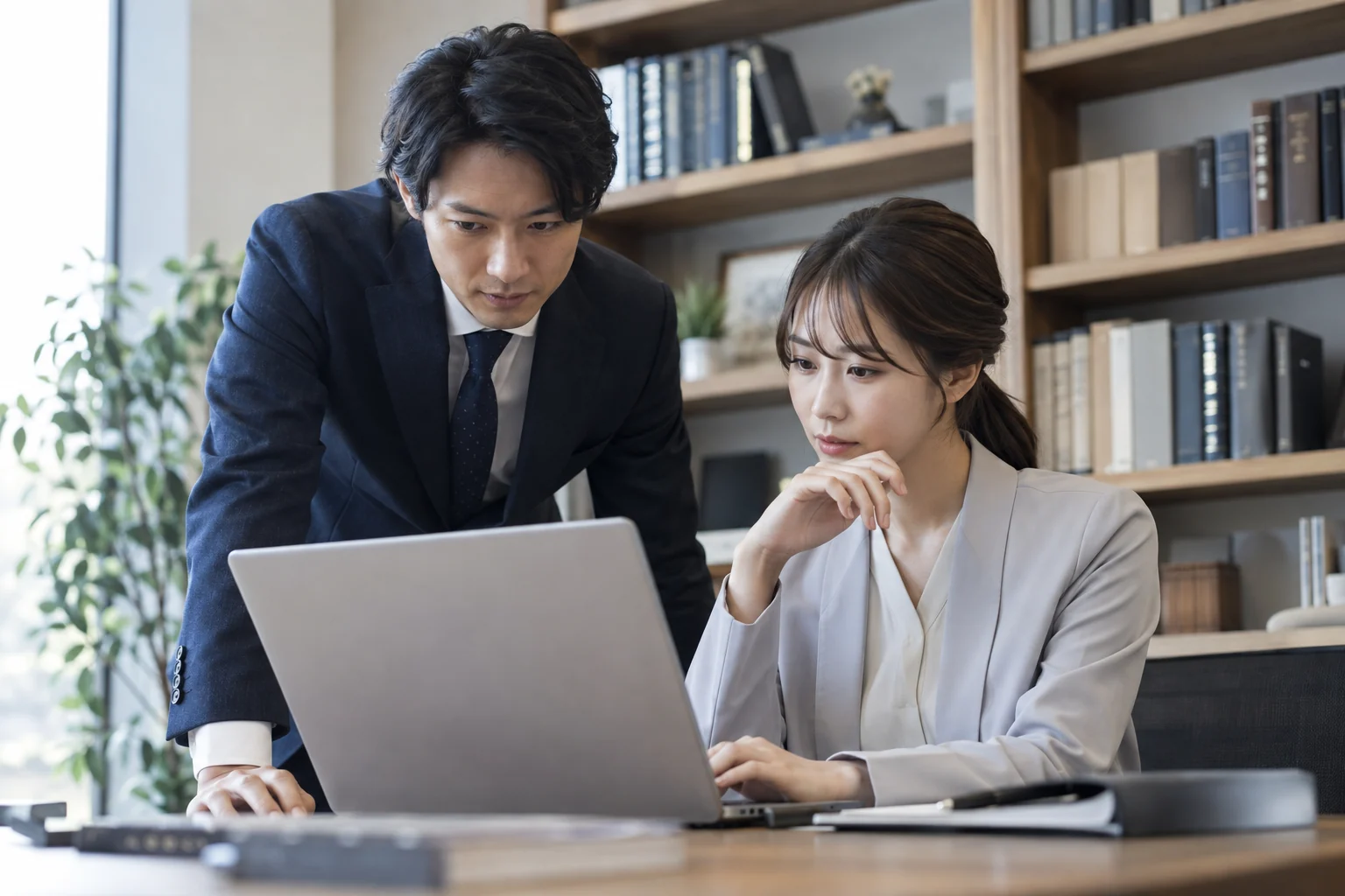 資料を共有して確認する二人の会計スタッフ